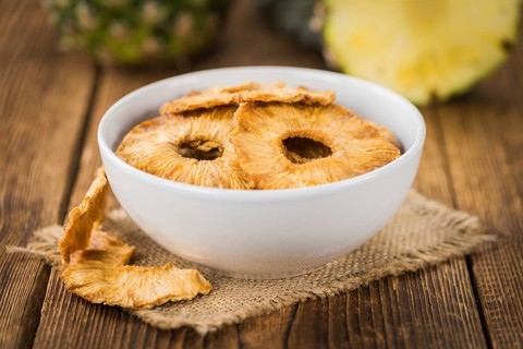 Dried Pineapple Rings on a vintage background as detailed close-up shot, selective focus