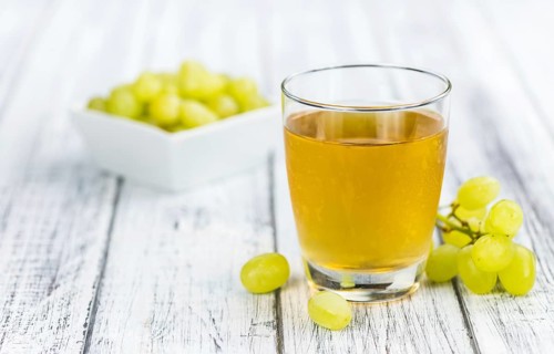 Wooden table with Grape Juice (detailed close-up shot, selective focus)