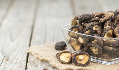 Fresh made Shiitake mushrooms (dried) on an old and rustic wooden table, selective focus, close-up