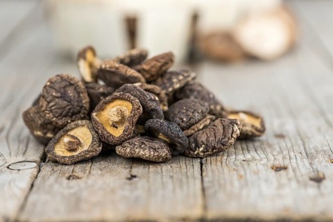 Fresh made Shiitake mushrooms (dried) on an old and rustic wooden table, selective focus, close-up