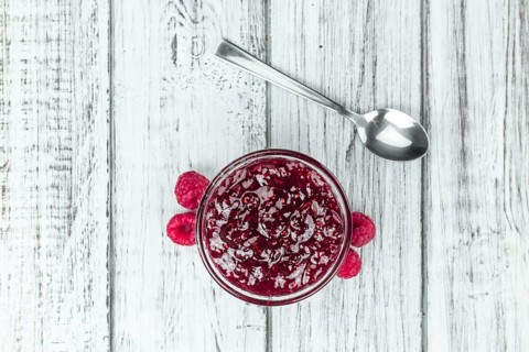 Fresh made Raspberry Jam on a vintage background as detailed close-up shot