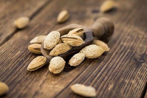 Roasted and salted Almonds (with shell) on a vintage background (close-up shot)
