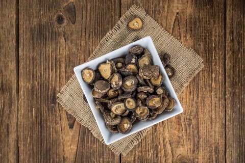 Fresh made Shiitake mushrooms (dried) on an old and rustic wooden table, selective focus, close-up