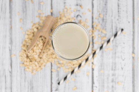Wooden table with Oat Milk (detailed close-up shot, selective focus)