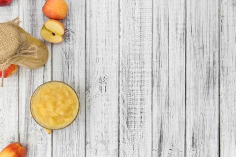 Old wooden table with fresh made Applesauce (selective focus, close-up shot)