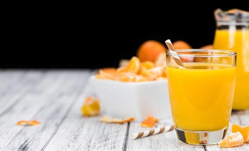 Homemade Tangerine Juice (close-up shot, selective focus) on a rustic background