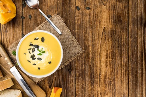 Fresh made Pumpkin Soup (close-up shot) on a vintage background (selective focus)