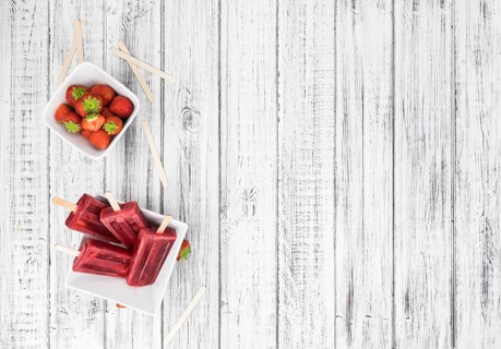 Strawberry Popsicles (close-up shot, selective focus) on a rustic background