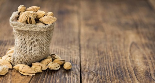 Roasted and salted Almonds (with shell) on a vintage background (close-up shot)
