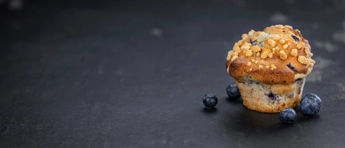Portion of healthy Blueberry Muffins on a slate slab (selective focus)