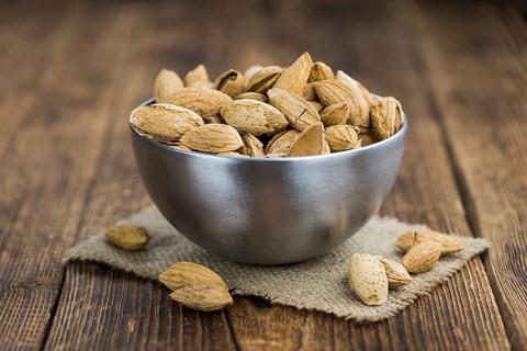 Almonds in shell (roasted and salted) on a vintage background (close-up shot)