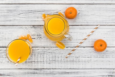 Portion of fresh made Tangerine Juice (close-up shot, selective focus)