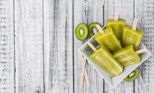 Kiwi Popsicles on an old wooden table (selective focus)