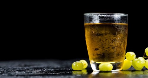 Some healthy Grape Juice on a vintage slate slab (selective focus)