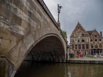 Historic bridge with neighbouring buildings and cloudy sky in the old town, Ghent, Belgium, Europe