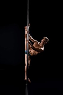 Young fair athletic man exercising on pylon studio shot