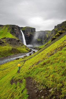 Hikers in a green canyon, Haifoss and Granni waterfall at a canyon, Fossá í Thjórsárdal, with river