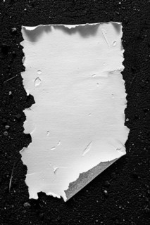 A piece of white paper with rugged edges set against a black background, AI generated