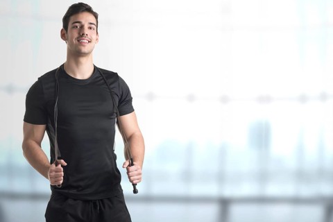 Fit athlete jumping rope, in a gym