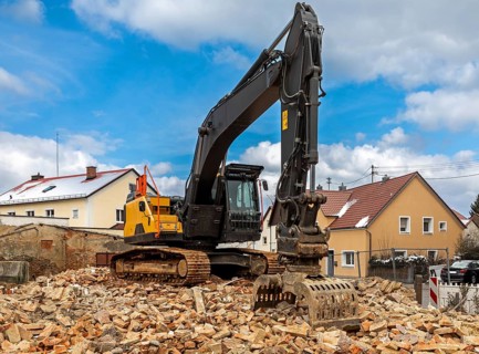Excavator on the rubble of a demolished building