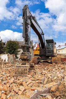Excavator on the rubble of a demolished building