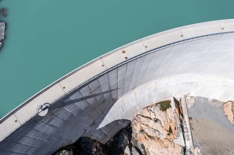 Aerial view of reservoir dam Barrage du Vieux Emosson and mountain hut Cabane Vieux Emosson,