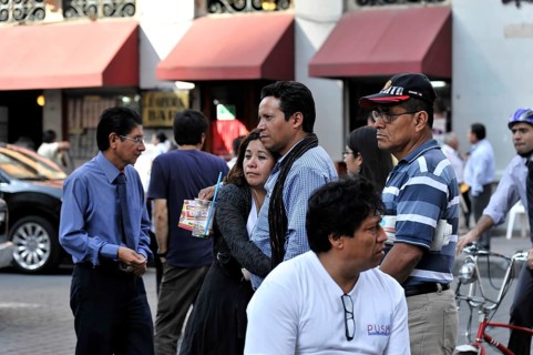 Mexico City, Mexico, Central America, crowd on the street, some engrossed in conversation, others
