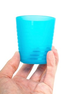Empty blue plastic glass, held in a male persons hand