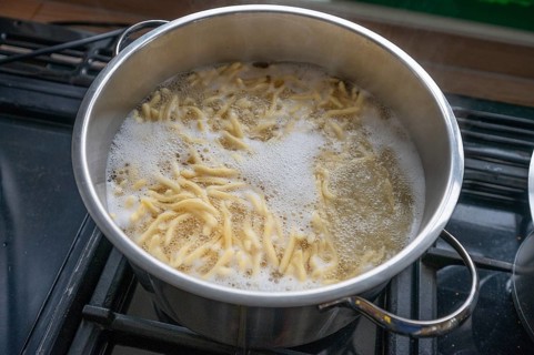 Boiling spaetzle in a pot, Bavaria Germany
