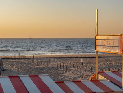 Sunset on the beach with a sign indicating the beach section, De Haan, Flanders, Belgium, Europe