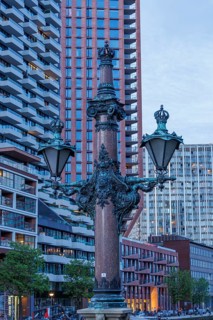 A magnificent lamppost in front of modern buildings at dusk, rotterdam, the netherlands
