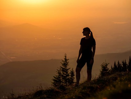 Silhouette of a young slender woman on a mountain meadow in the evening light, Schlenken, Bad