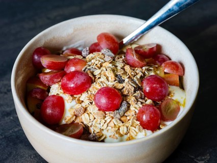Fresh homemade muesli with organic red grapes and oat flakes, close-up