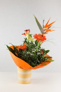 A bouquet of roses, carnations and orchids in a vase