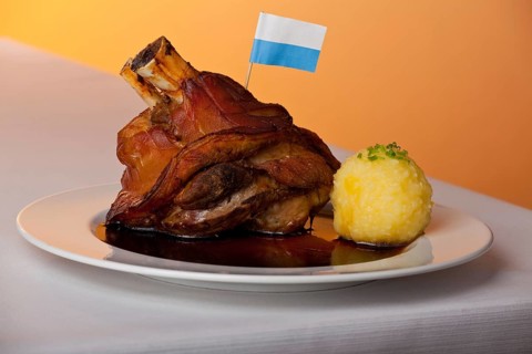 Pork knuckle with potato dumplings on a plate