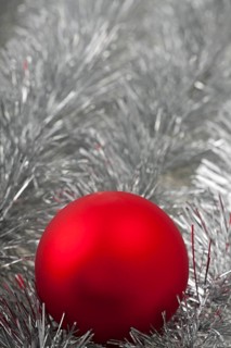 Red Christmas bauble on silver tinsel
