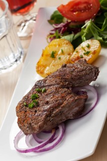 Steak with potato halves and salad
