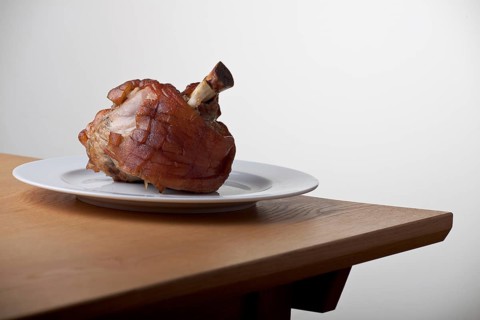 Grilled knuckle of pork on a wooden table