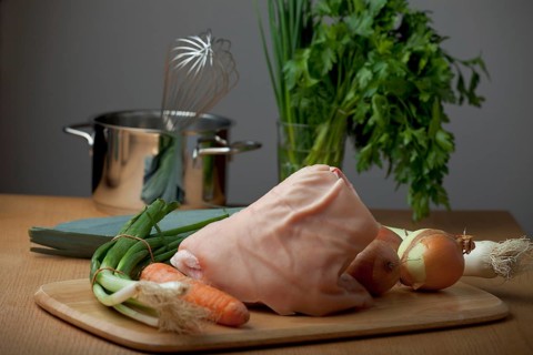 Raw knuckle of pork on a wooden table