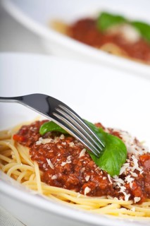 Plate with spaghetti bolognese and basil leaf