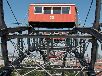 Detailed view of a red cabin of a Ferris wheel with a view of the city in the background, Vienna,