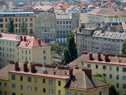 View of a city with various buildings, red roofs and chimneys on a sunny day, Vienna, Austria,