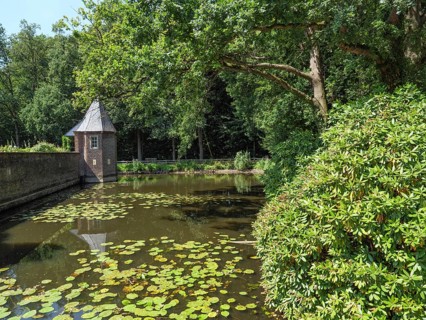 A quiet pond with water lilies, surrounded by trees and a small pavilion, ochtrup, münsterland,
