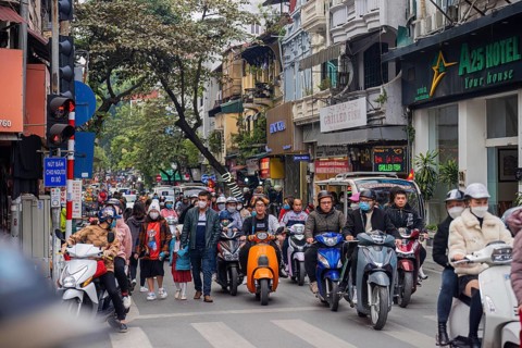 Vietnam Hanoi street scene with many scooters