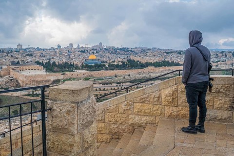 Young Israeli with machine gun overlooking Jerusalem Old City from Mount of Olives
