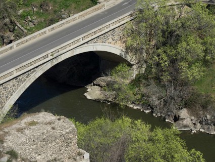 Stone bridge over a river with neighbouring trees and rocks, Toledo, Spain, Europe