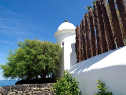 White domed tower and wooden fence with green plants under a blue sky, Puerto de la cruz, tenerife,