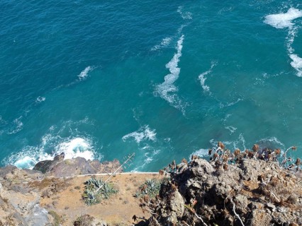 View from a cliff to the blue foaming sea and the rocky coast, Puerto de la cruz, tenerife, spain