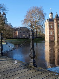 Beautiful castle with moat, bridge and close-up of a wooden footbridge with chains, ruurlo,