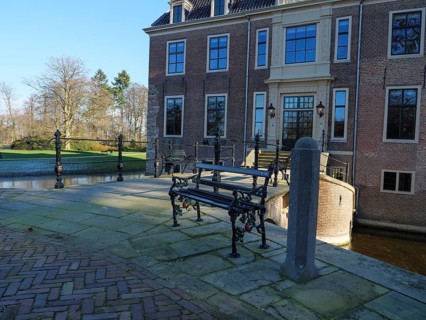 Bench in front of the entrance area of a historic castle, with cobblestones and a quiet atmosphere,